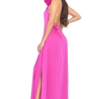 Vestido largo fucsia de silueta fluida y escote halter adornado con una imponente flor artesanal al cuello