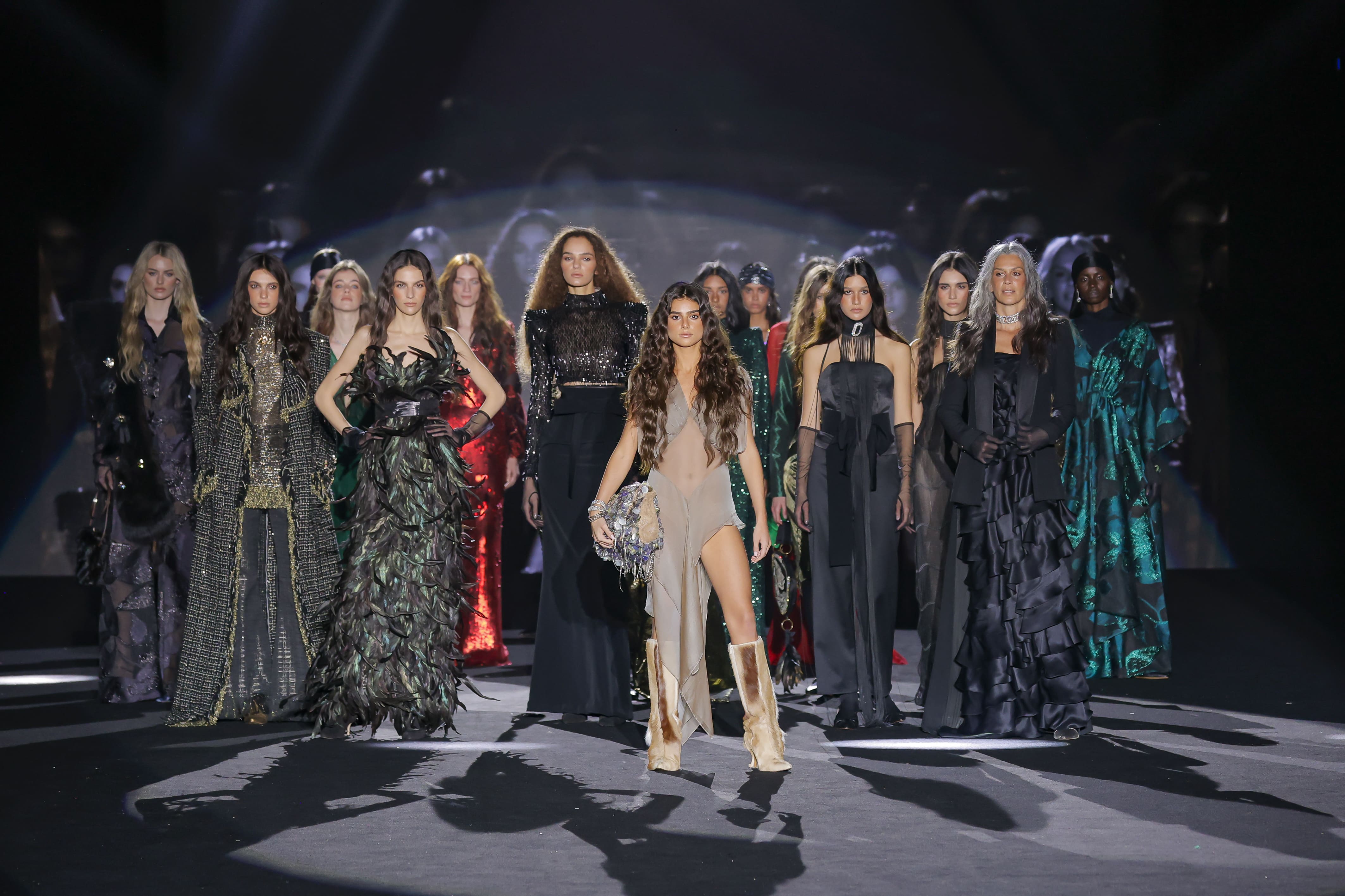 El cierre del desfile adquiere aquí una fuerza cinematográfica. Sobre la pasarela, las modelos se disponen en formación, avanzando con determinación, como una constelación de musas modernas