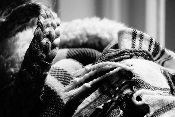 Detalle en blanco y negro de tejidos artesanales y fibras trenzadas, evocando la tradición textil y la artesanía del movimiento slow fashion.