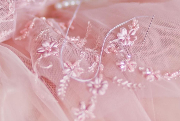 Detalle artesanal de encaje en tul rosa empolvado, una de las alternativas más elegantes al vestido de novia blanco tradicional.