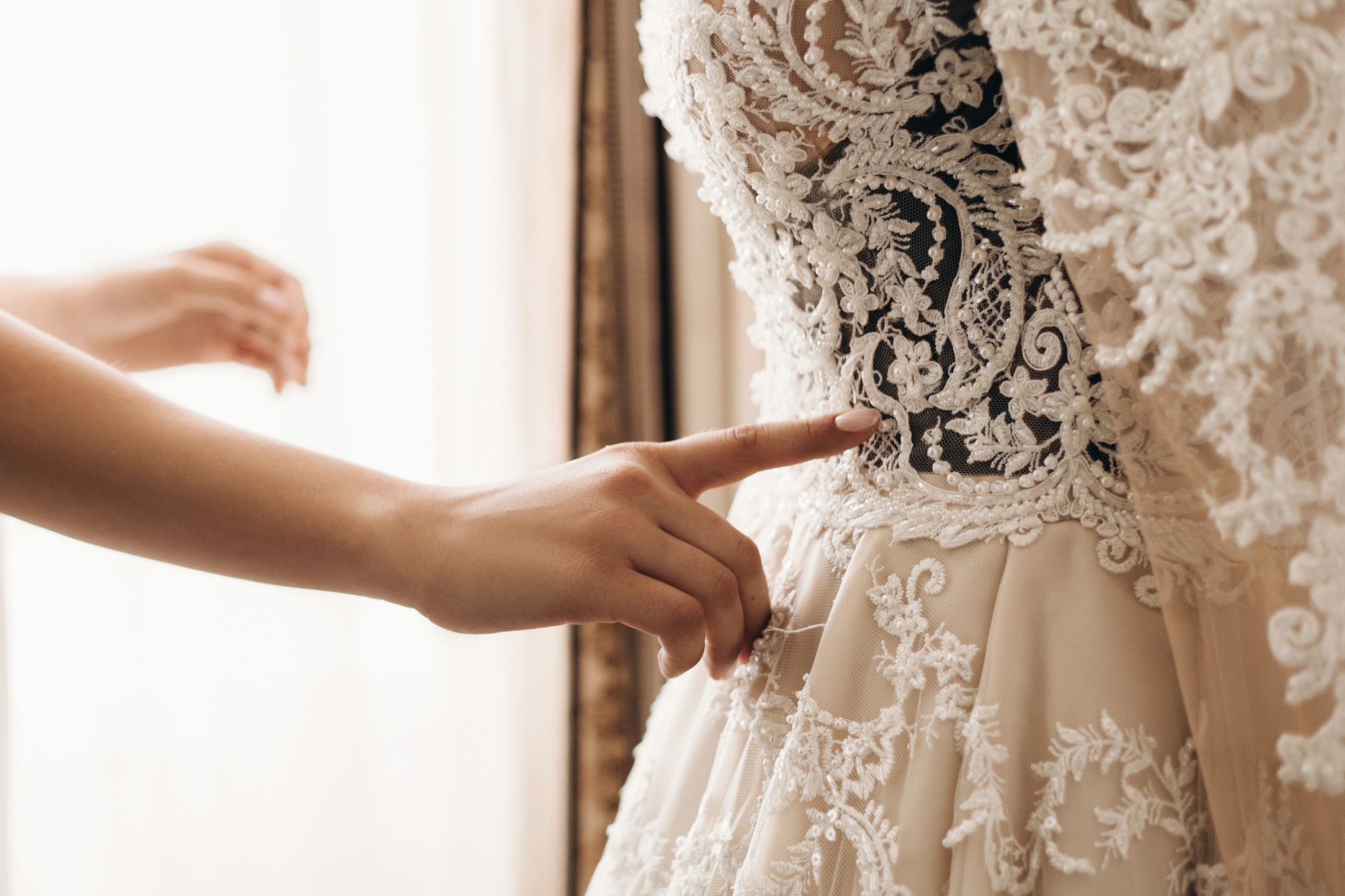 Detalle de un vestido de novia con pedrería bordada, ejemplo de alta costura y técnicas artesanales en moda nupcial lujosa.