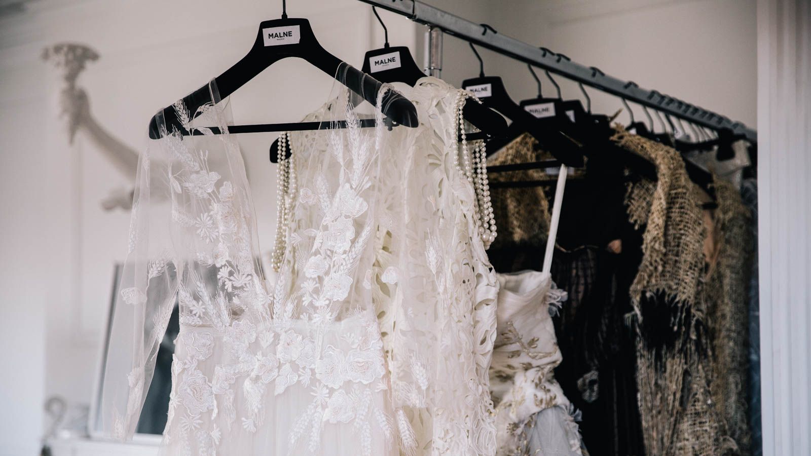 Vestidos prêt-à-couture colgados en atelier, con bordados artesanales y tejidos nobles pensados para el día a día con elegancia atemporal.
