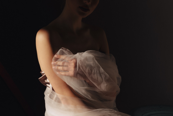 Manos cuidando una prenda de lujo con delicadeza, reflejando la artesanía y el detalle del atelier Malne.