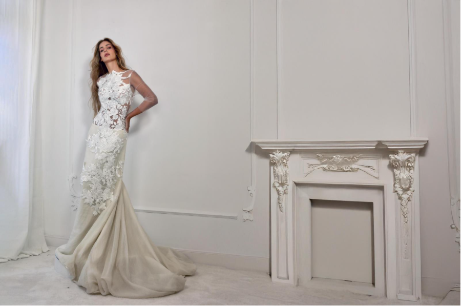 Modelo de Malne con vestido blanco de encaje y cola larga en un salón elegante.