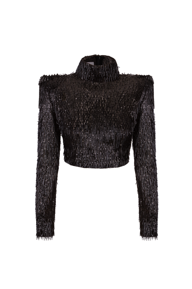Top negro de manga larga con hombreras y cuello alto, cubierto de lentejuelas verticales brillantes.