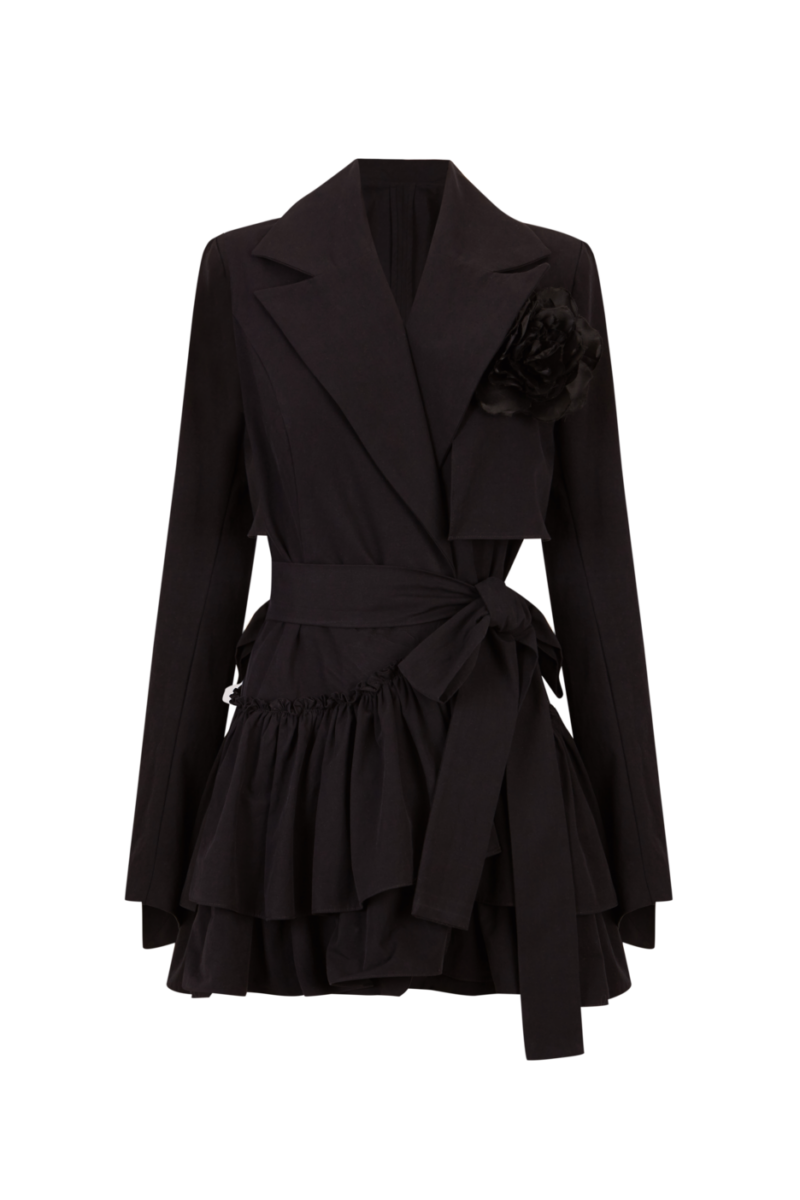Vestido tipo blazer negro con volantes y cinturón, decorado con una flor negra en el pecho.
