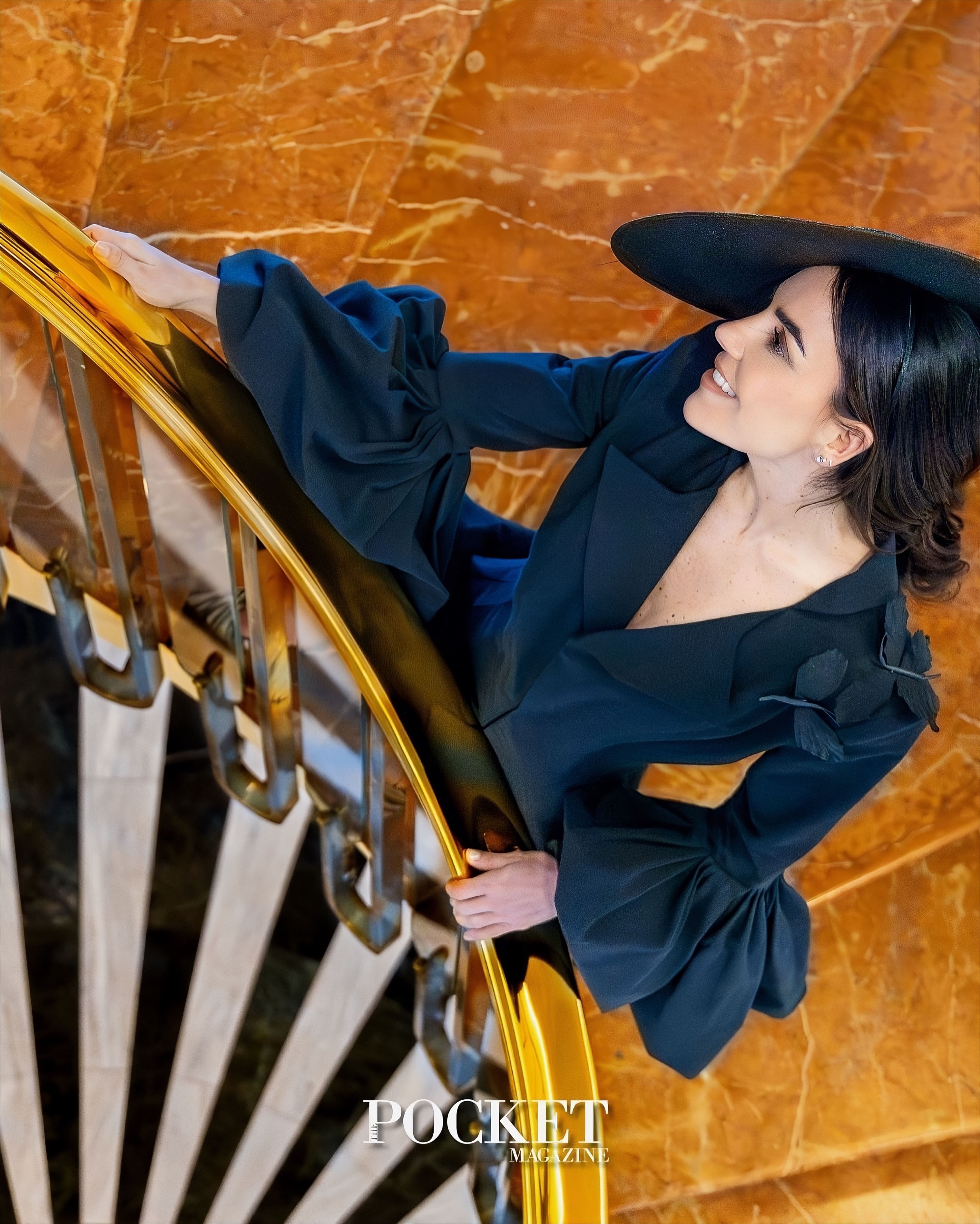 Fotografía editorial de una mujer elegante con sombrero negro en una escalera de mármol, utilizada como portada de "POCKET MAGAZINE" y asociada al estilo de MALNE.