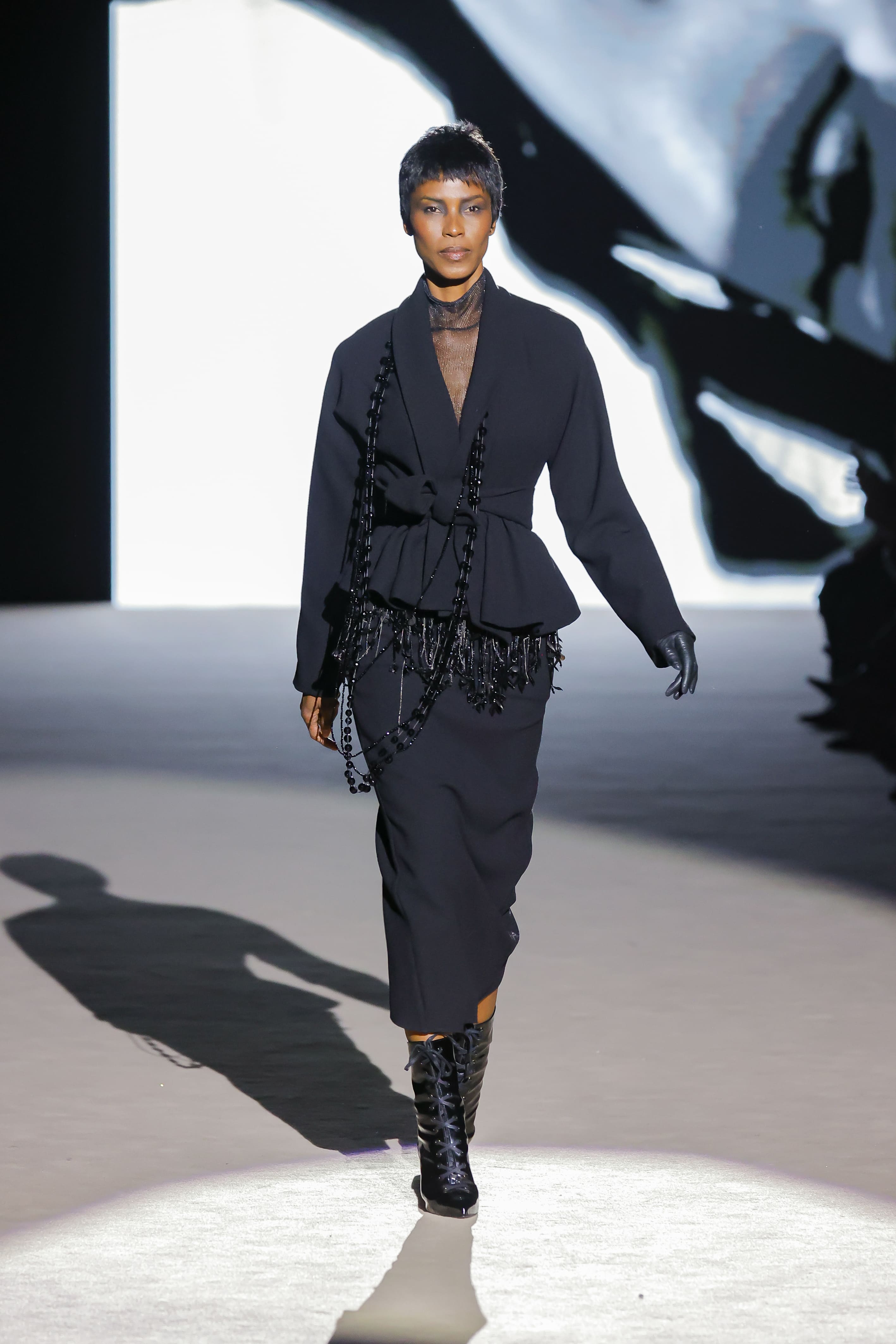Modelo con conjunto negro estructurado con detalles de cuentas de Malne en la Mercedes-Benz Fashion Week Madrid marzo de 2026 y botas negras.