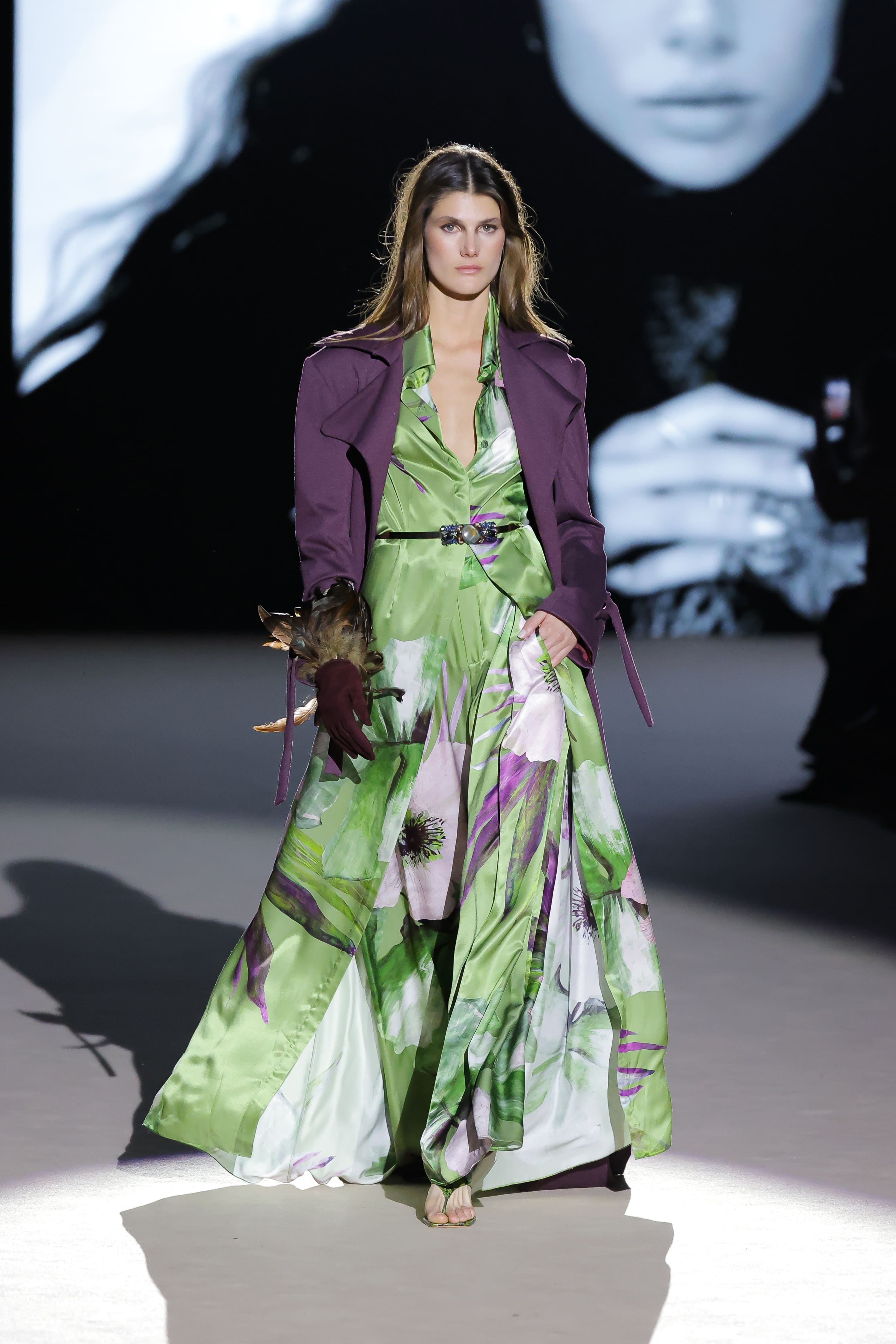 Modelo con vestido estampado floral verde y abrigo morado de Malne en la Mercedes-Benz Fashion Week Madrid marzo de 2026 con guantes decorados.