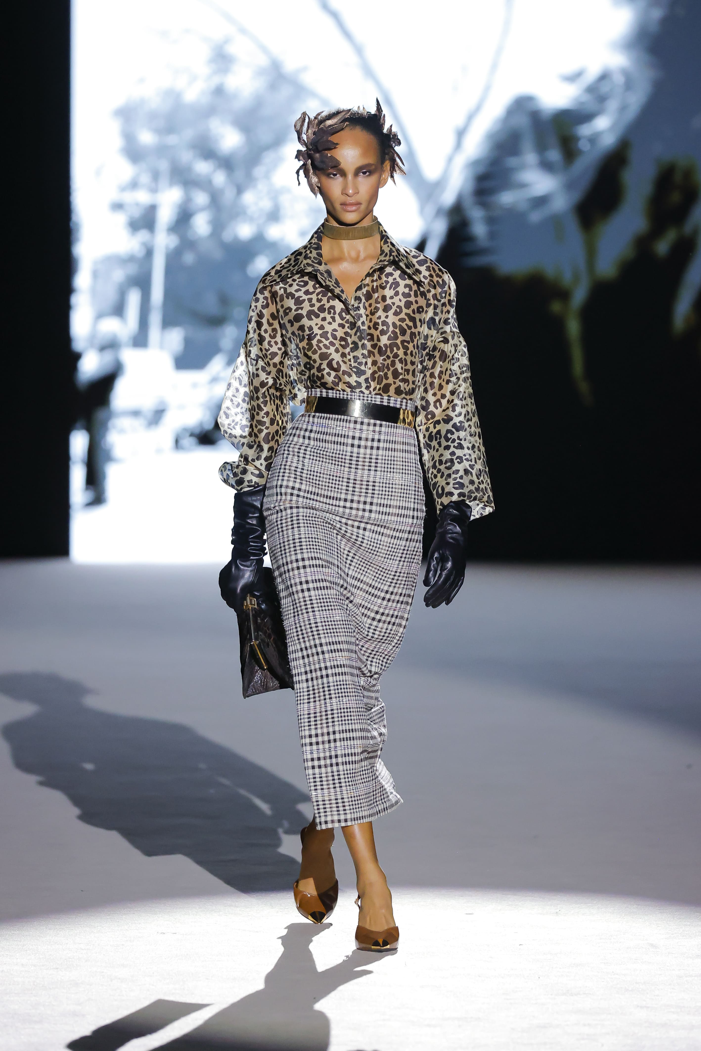 Modelo con blusa de estampado animal y falda de cuadros de Malne en la Mercedes-Benz Fashion Week Madrid marzo de 2026 con cinturón ancho y guantes.