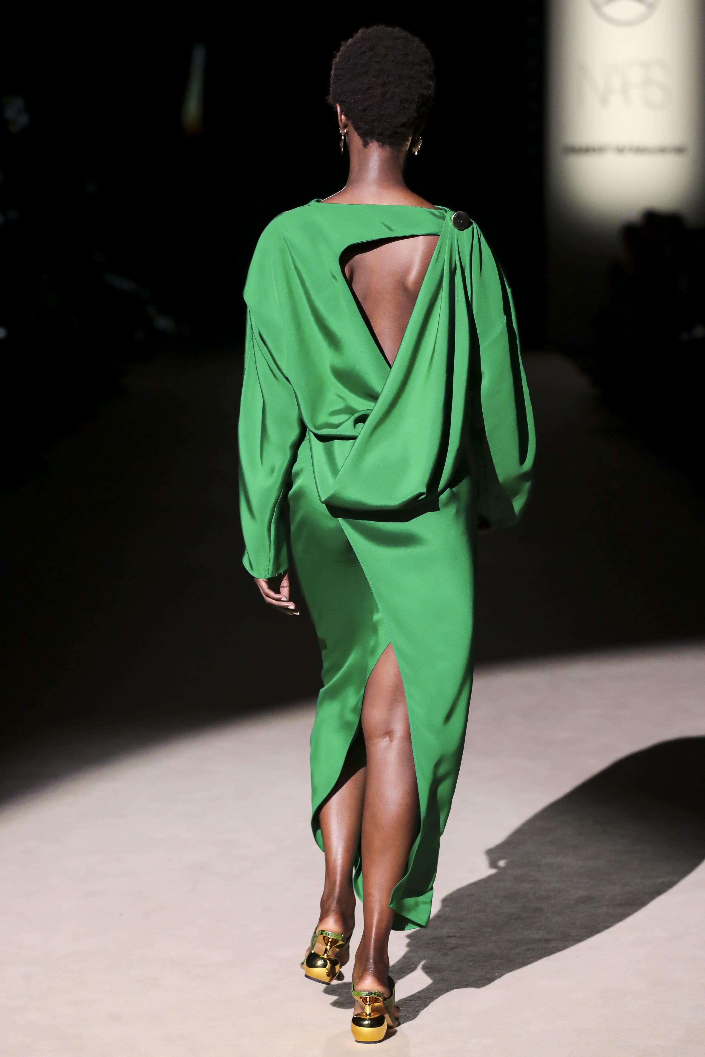 Modelo desfilando de espaldas con vestido verde fluido de Malne en la Mercedes-Benz Fashion Week Madrid marzo de 2026 con espalda abierta.