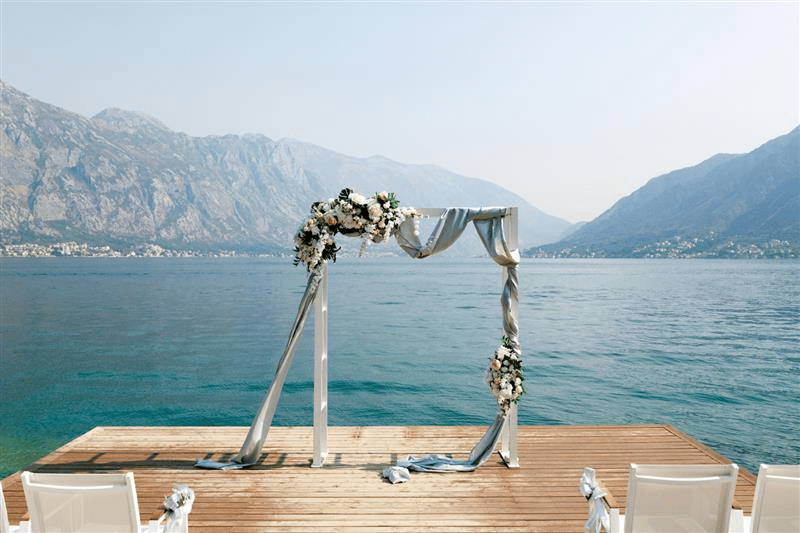 Arco de boda decorado con flores sobre un muelle frente al Lago de Como